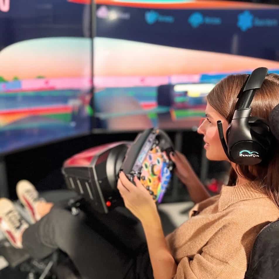 Happy girl racing simulator hire with a motion platform in London, UK.