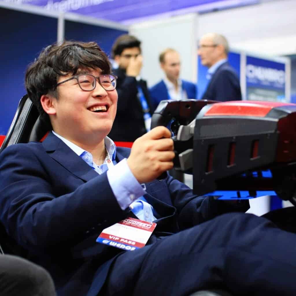 Happy man from China at a Formula simulator on a CloudFest.