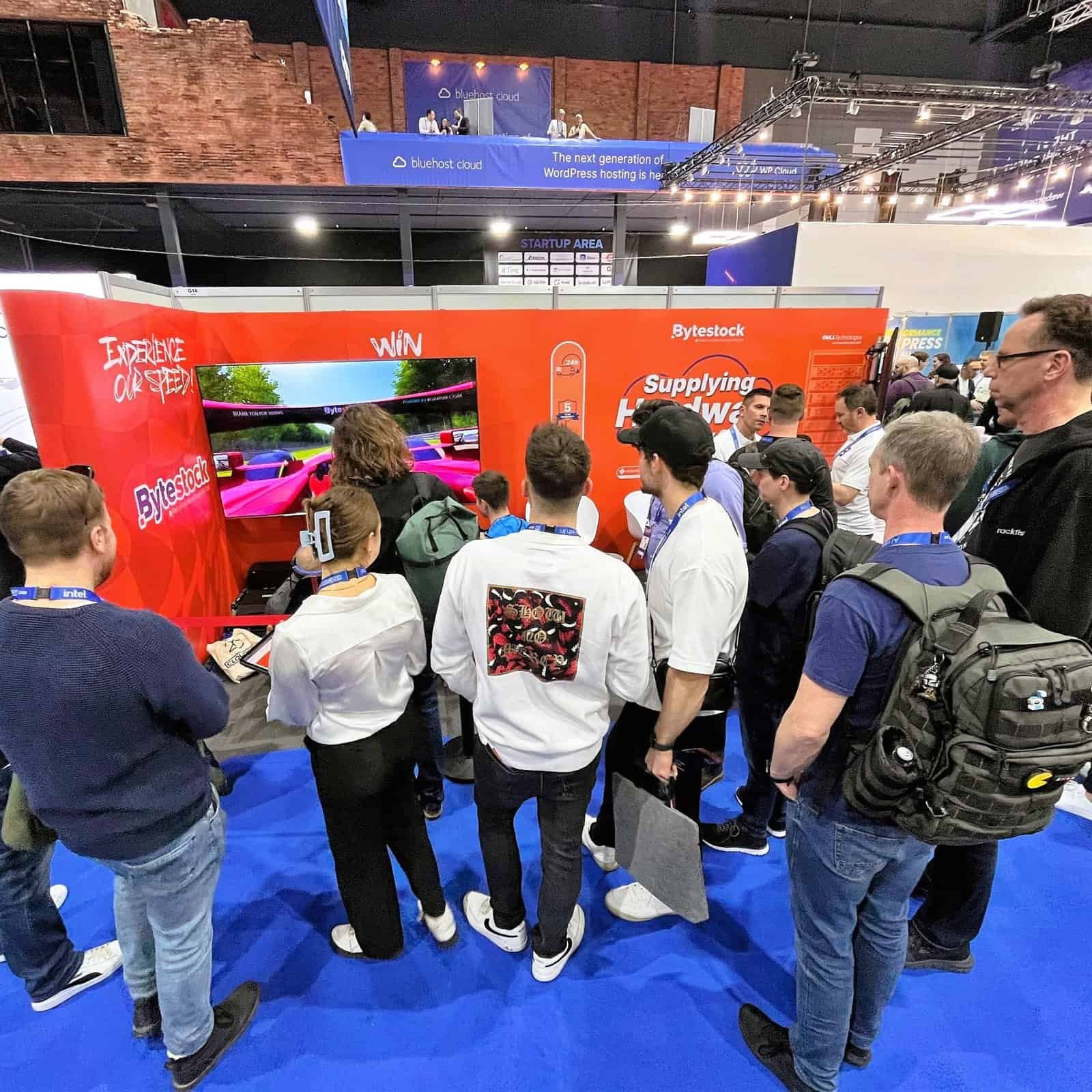 A big crowd around a F1 licensed seat motion simulator to generate leads in effective at a CloudFest.