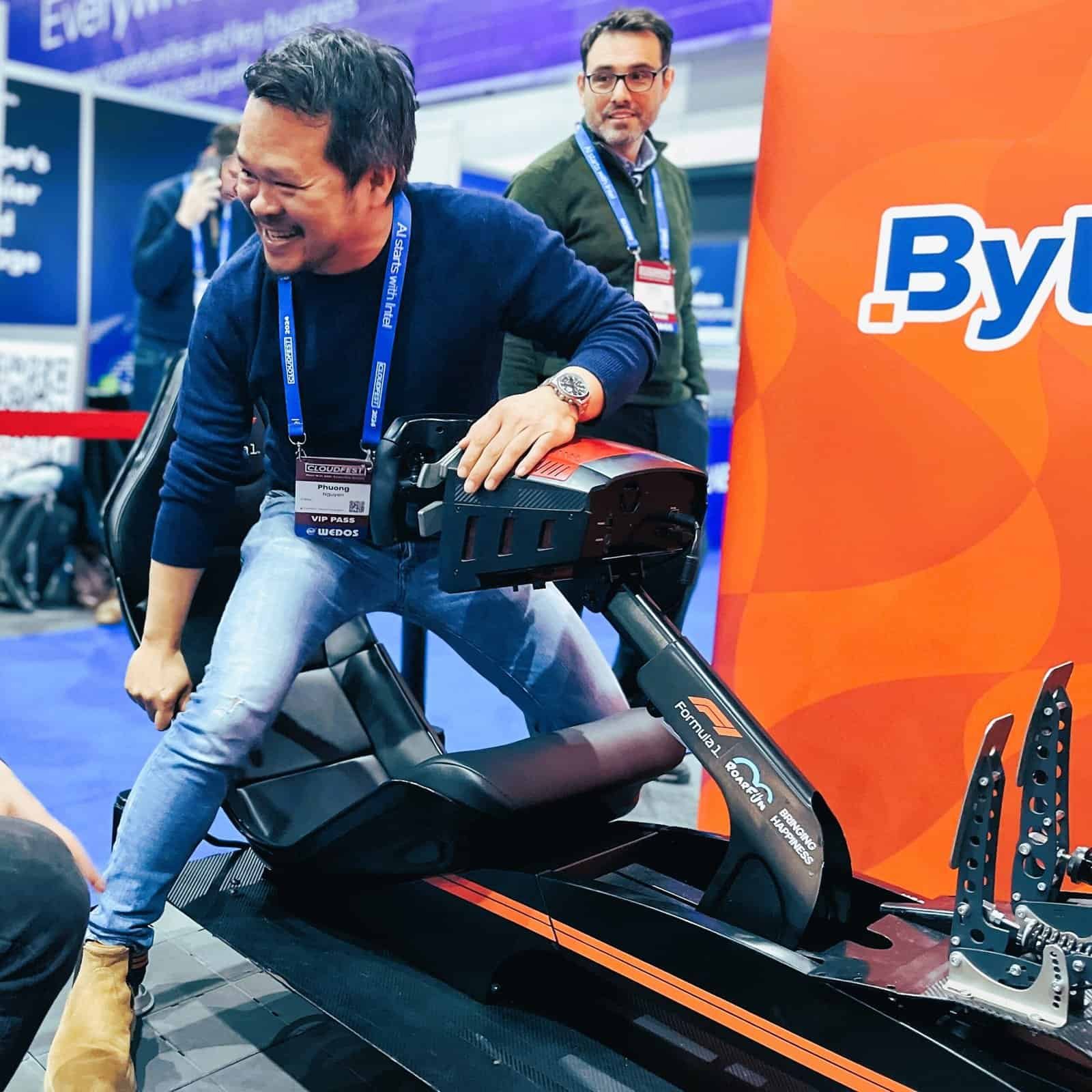 Happy man finished playing the F1 simulator at a cloudfest conference.