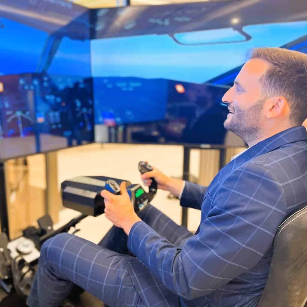 Happy guy playing on flight simulator.